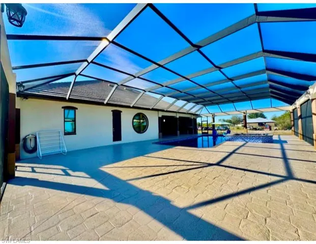 View of swimming pool with a patio and glass enclosure