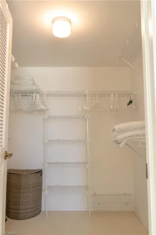 Well-organized closet featuring wire shelving, hanging rods, and a ceiling-mounted light fixture