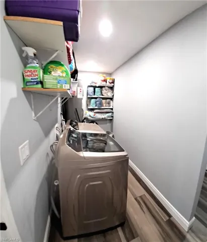 Laundry room featuring hardwood / wood-style flooring and washer / clothes dryer