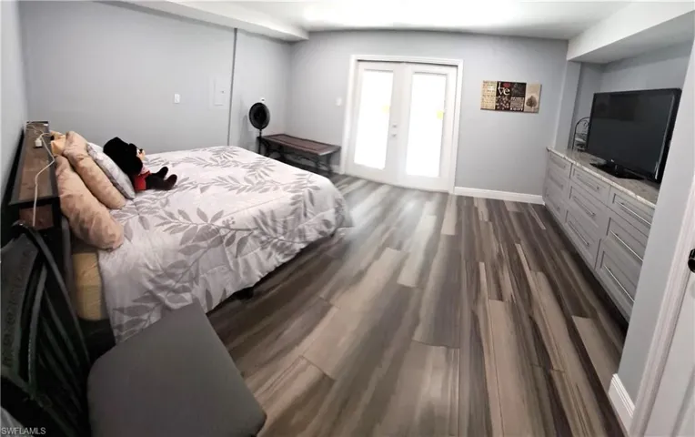 Bedroom featuring dark hardwood / wood-style flooring and french doors