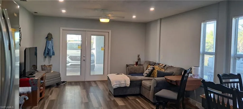 Living area with ceiling fan, french doors, and wood-type flooring