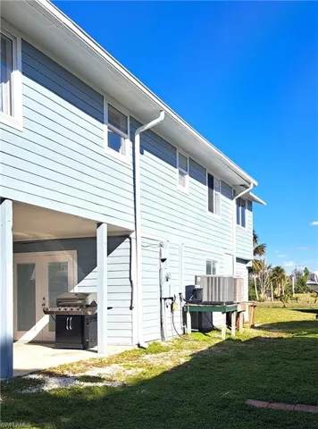 Side view of property with a lawn