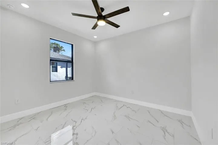 Spare room with ceiling fan, marble finish floor, recessed lighting, and baseboards