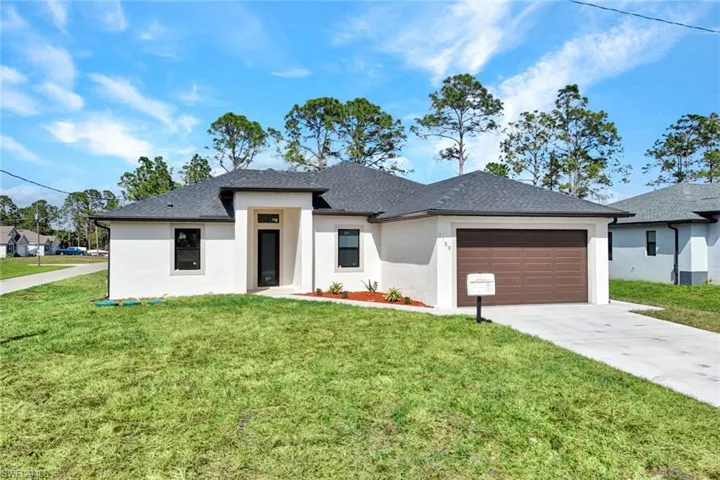 Prairie-style home featuring a garage, concrete driveway, roof with shingles, stucco siding, and a front yard