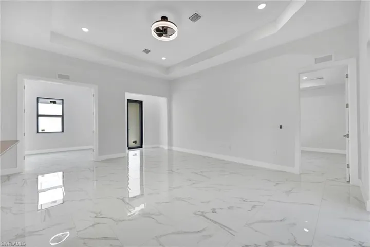 Spare room featuring recessed lighting, a raised ceiling, visible vents, and baseboards