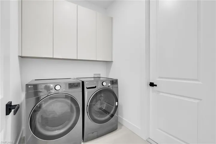 Washroom with washer and dryer and cabinet space