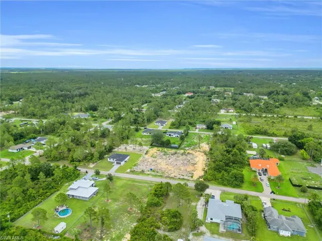Aerial overview of property's location with a forest and nearby suburban area