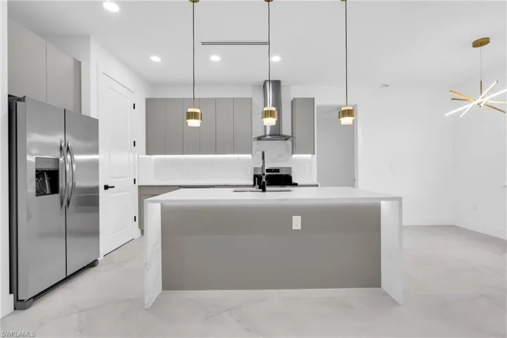 Kitchen featuring stainless steel appliances, wall chimney range hood, modern cabinets, gray cabinets, and recessed lighting