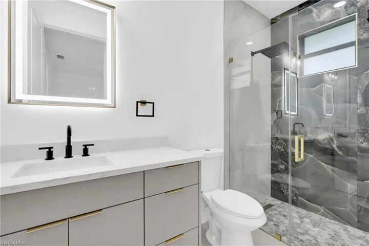 Full bathroom with vanity and a marble finish shower