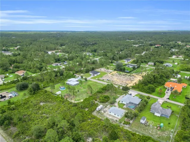 View of property location with a heavily wooded area and nearby suburban area