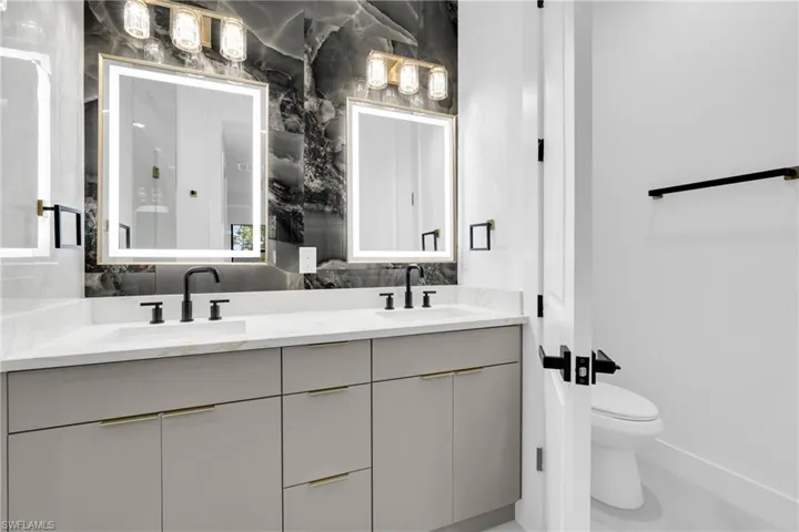 Bathroom with double vanity and decorative backsplash