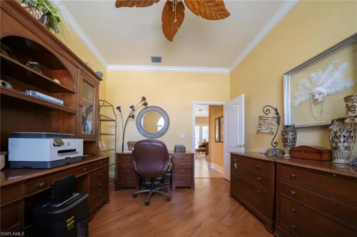Office space featuring crown molding, ceiling fan, and wood-type flooring