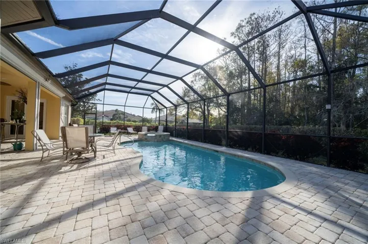 View of swimming pool with an in ground hot tub, a lanai, ceiling fan, and a patio area