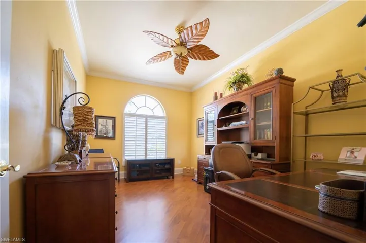 Office with crown molding, wood-type flooring, and ceiling fan