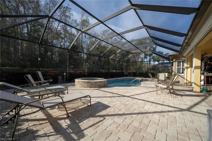 View of pool with a lanai, a patio, and an in ground hot tub
