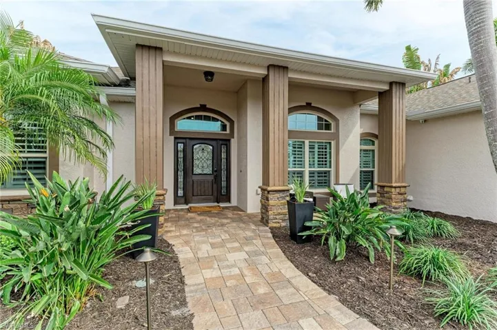 Doorway to property with stucco siding and a porch