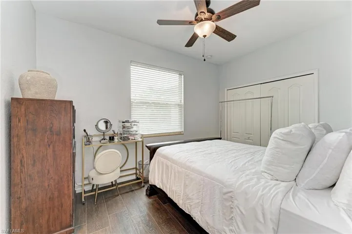 Bedroom with dark wood finished floors, a closet, and ceiling fan