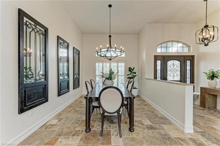 Dining space featuring hanging lights, light stone finish flooring, and healthy amount of natural light