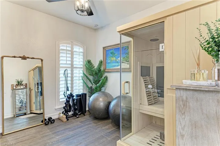 Workout room featuring a relaxing sauna and light wood-style flooring