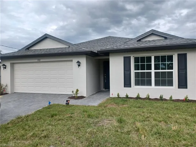 Ranch-style house with stucco siding, a front lawn, decorative driveway, and a garage