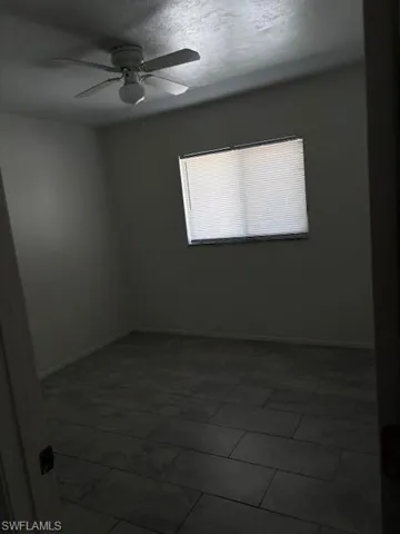 Spare room with ceiling fan and a textured ceiling