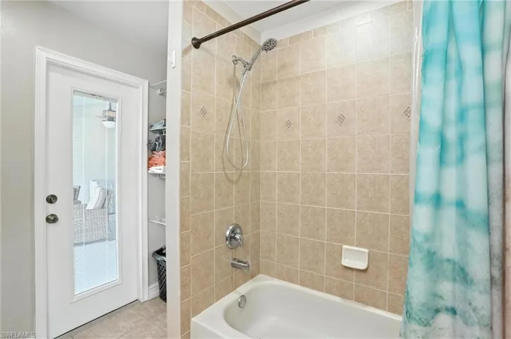 Full bathroom featuring shower / bathtub combination with curtain and tile patterned floors