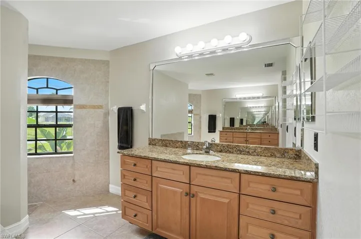 Bathroom featuring vanity, tile patterned flooring, and a walk in shower