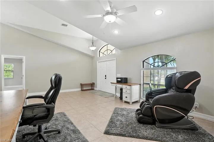 Office space with light tile patterned flooring, recessed lighting, a ceiling fan, and high vaulted ceiling