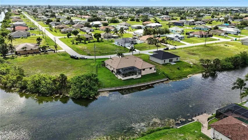 Aerial perspective of suburban area featuring a nearby body of water