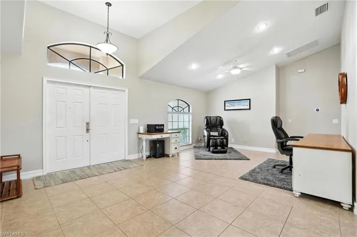 Foyer entrance featuring high vaulted ceiling, light tile patterned floors, and a ceiling fan
