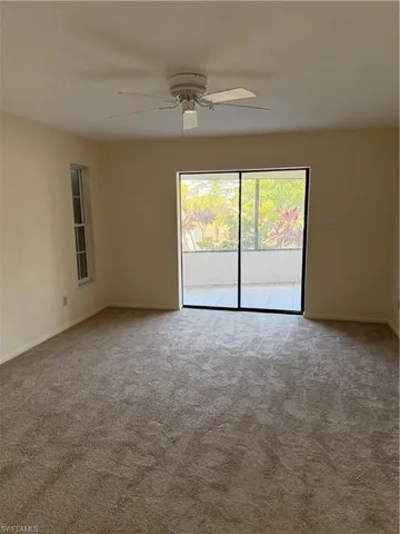 Spare room featuring ceiling fan and light colored carpet