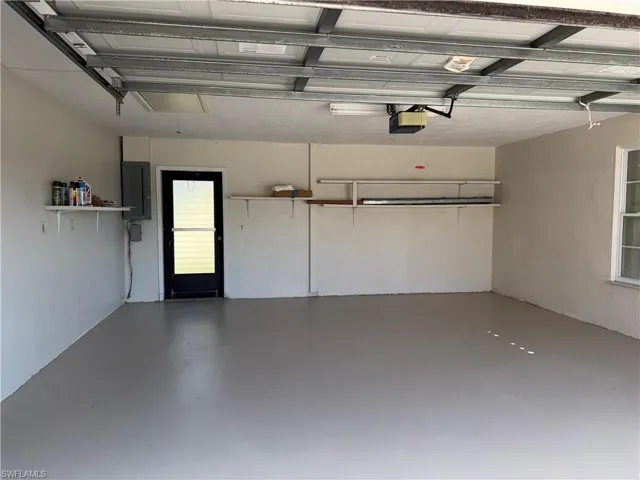 Garage featuring electric panel and a garage door opener