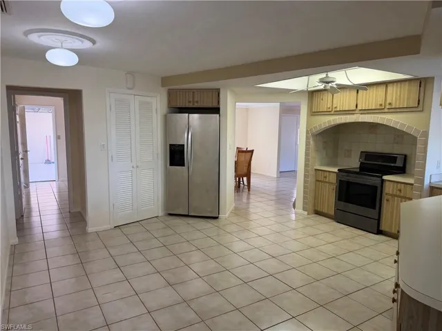 Kitchen featuring light countertops, ceiling fan, stainless steel appliances, and light tile patterned flooring