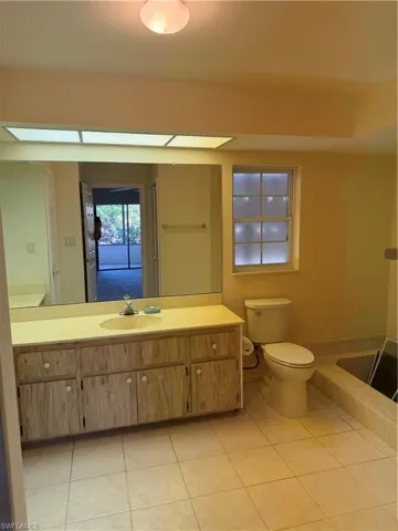 Full bath with vanity and light tile patterned floors