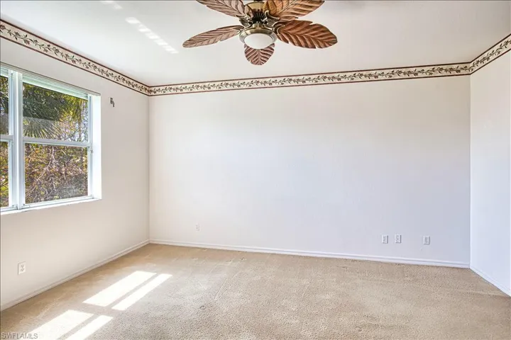 Unfurnished room with baseboards, light colored carpet, and ceiling fan