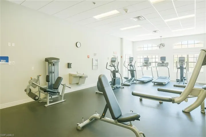 Gym featuring baseboards, visible vents, and a drop ceiling
