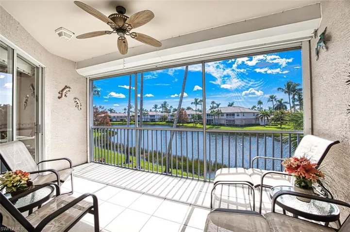 Sunroom / solarium with a water view and ceiling fan