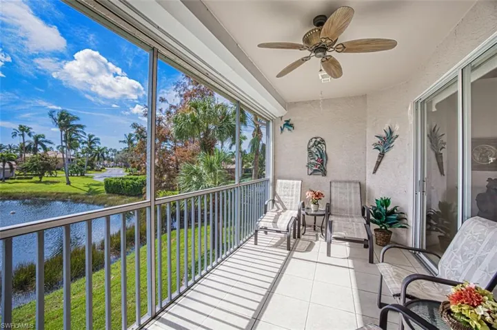 Sunroom / solarium featuring ceiling fan and a water view