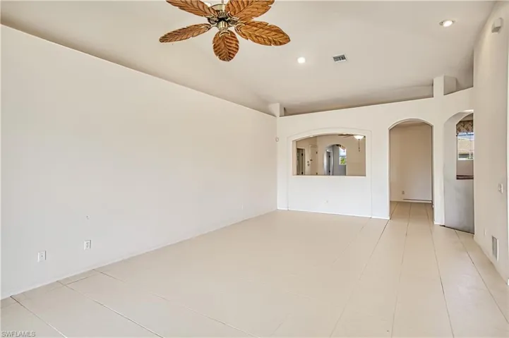 Unfurnished room featuring visible vents, recessed lighting, arched walkways, ceiling fan, and vaulted ceiling