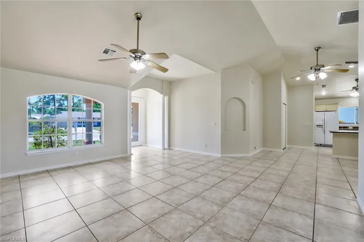 Living room featuring  lofted ceiling, and light tile floors