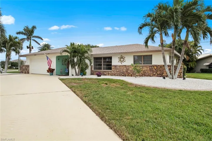 Ranch-style home with a front yard and a garage