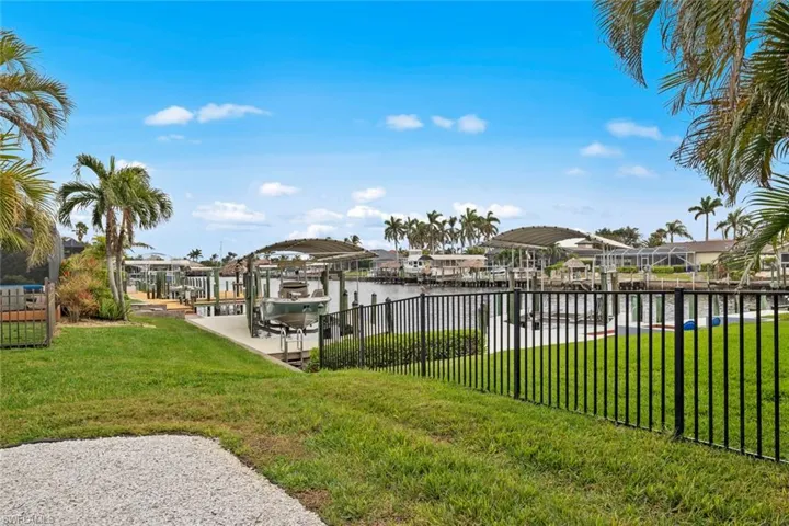 Dock area with a water view and a lawn