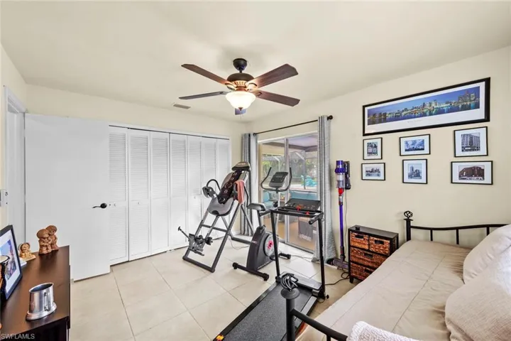 Bedroom featuring ceiling fan, light tile patterned floors, and a closet