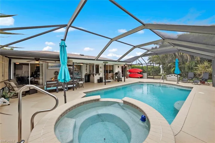 View of swimming pool featuring an in ground hot tub, a lanai, ceiling fan, and a patio area