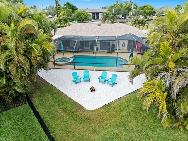 View of swimming pool featuring a yard, a patio, glass enclosure, and an in ground hot tub