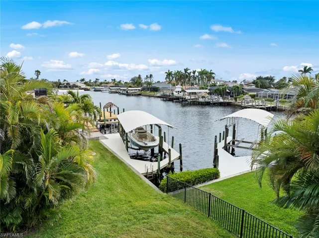 Dock area with a lawn and a water view