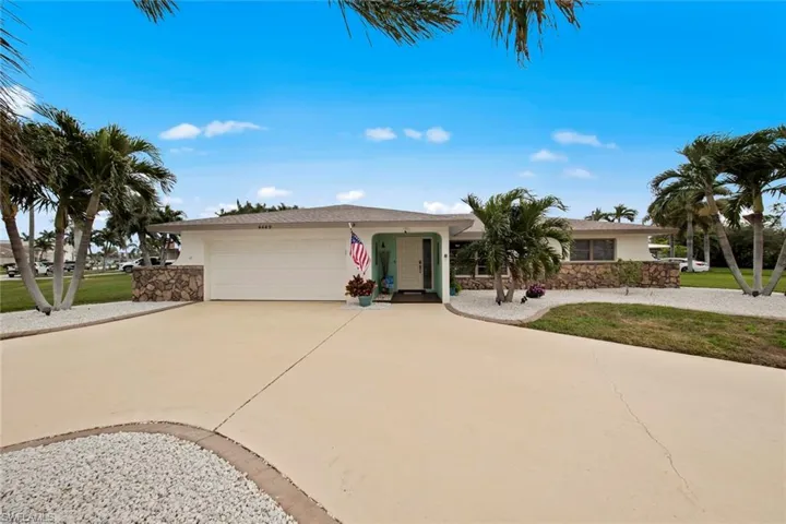 Ranch-style home with a front lawn and a garage