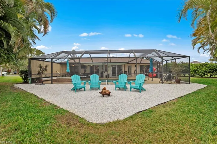 View of patio featuring glass enclosure and a fire pit