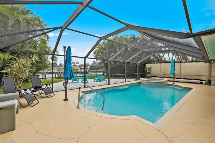 View of swimming pool featuring a lanai, a patio, and an in ground hot tub