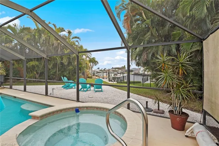 View of pool featuring a lanai, a patio area, and an in ground hot tub